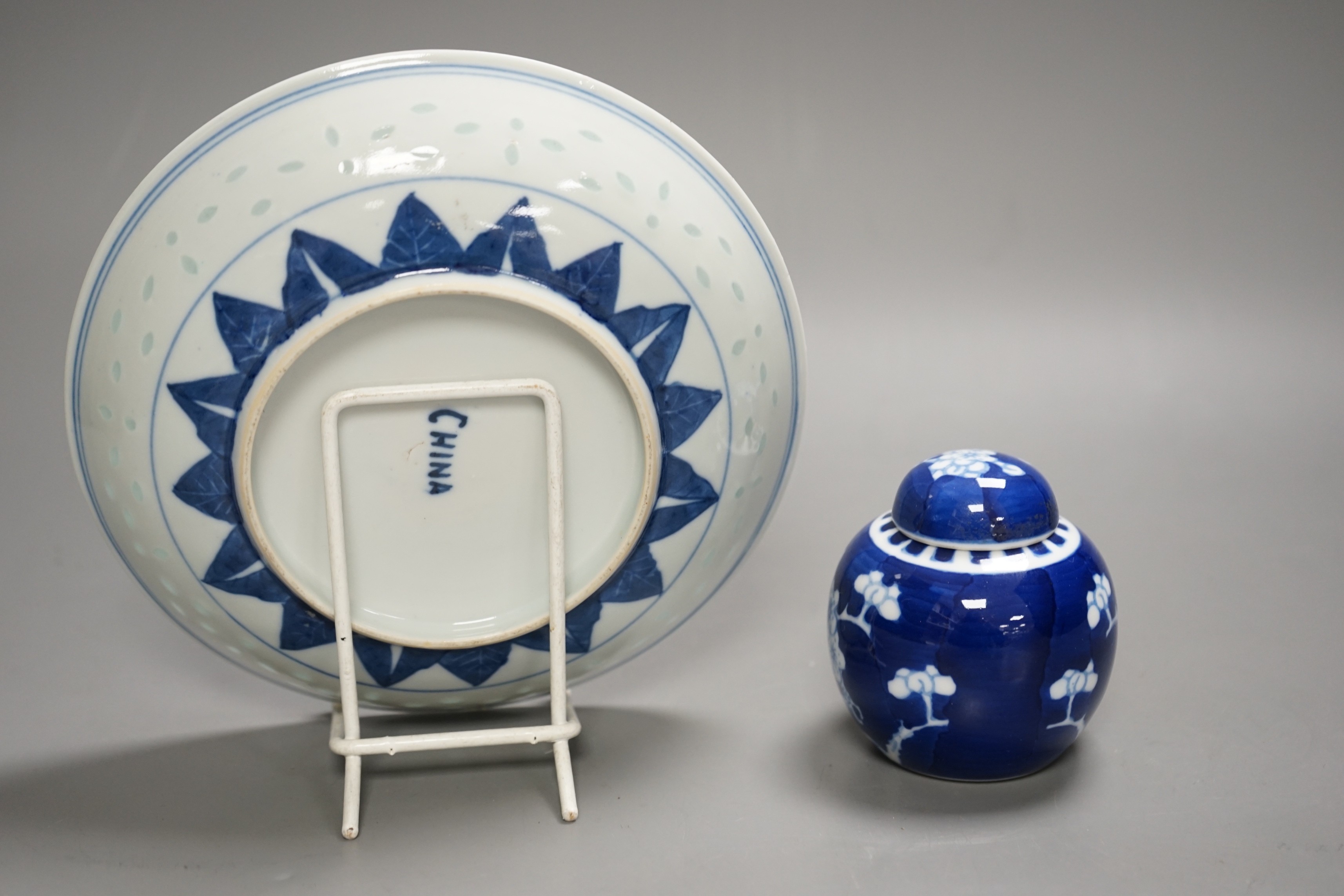 A Chinese blue and white dragon dish with rice grain border, early 20th century and a Chinese blue and white Prunus small jar and cover, dish 18cm diameter